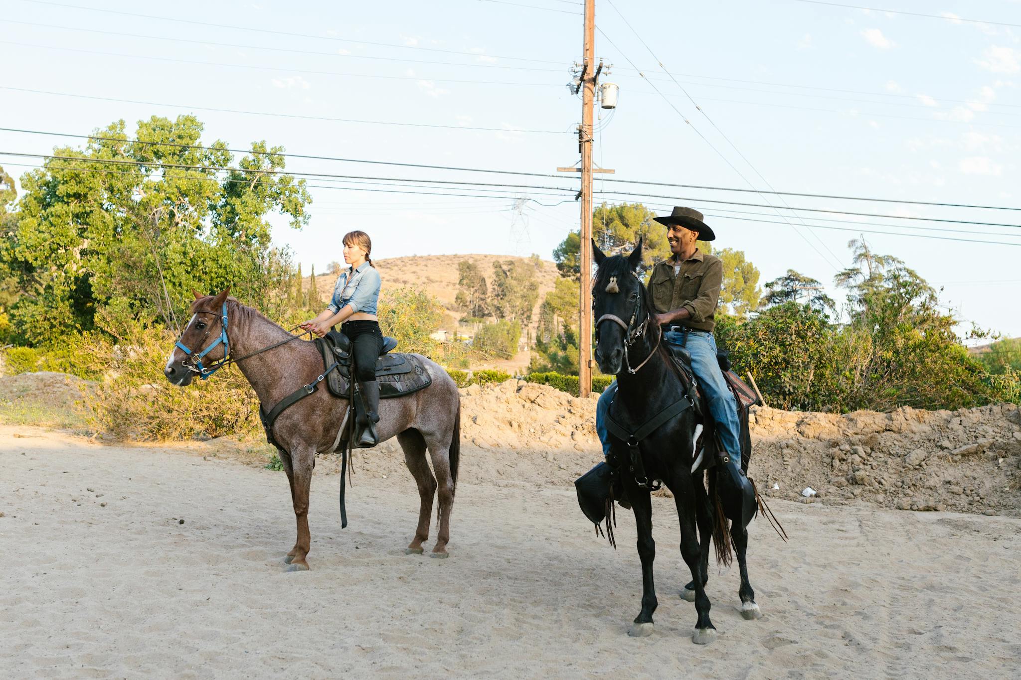 Two people riding horses outdoors, showcasing equestrian lifestyle and nature.